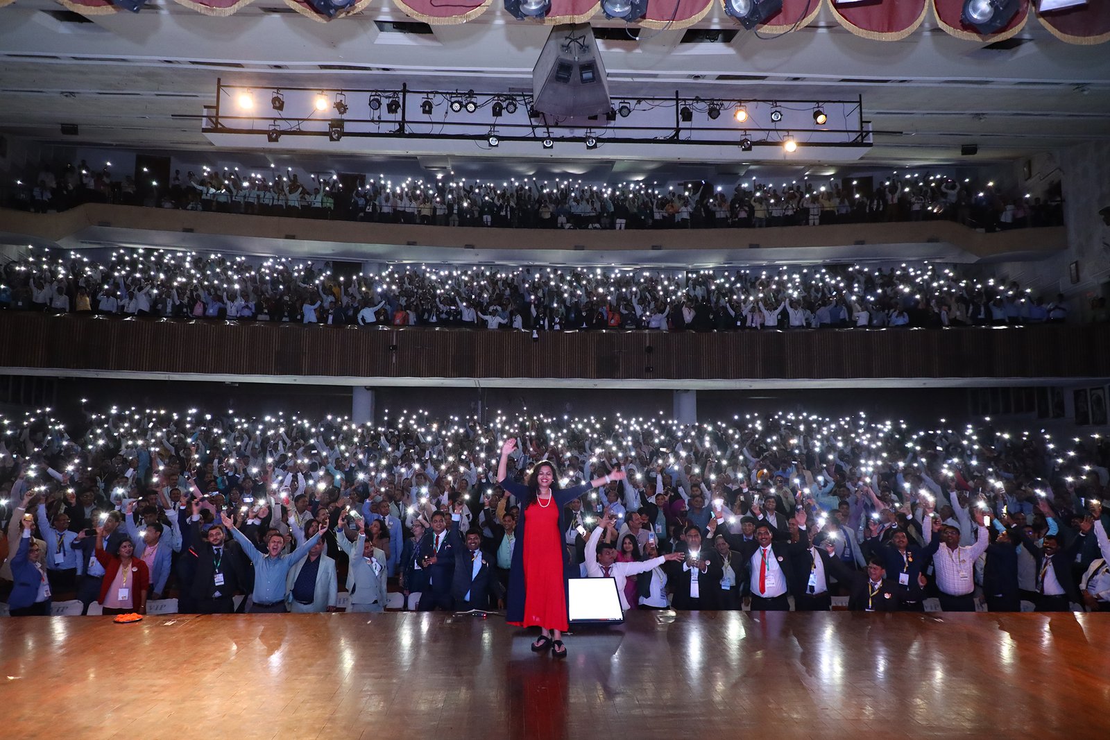 Himani on stage with a packed auditorium